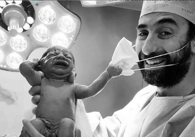 Foto della speranza,neonato strappa la mascherina al medico © ANSA