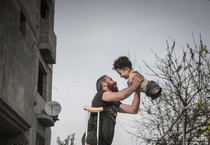 Mustafa, bambino siriano di 5 anni, nato senza braccia e gambe, con il padre  Munzir, in uno scatto simbolo delle tragedie del conflitto in Siria (ANSA)