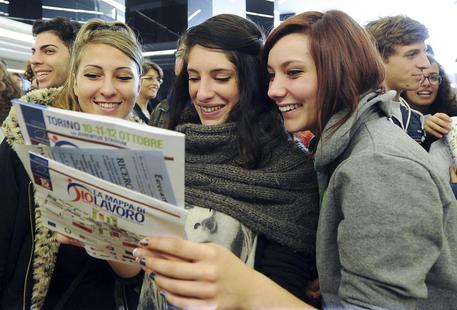 Tre ragazze con un giornale di annunci di lavoro in una foto d'archivio © ANSA