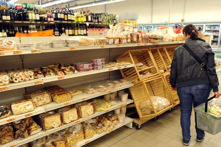 Una donna fa la spesa in un supermercato - RIPRODUZIONE RISERVATA