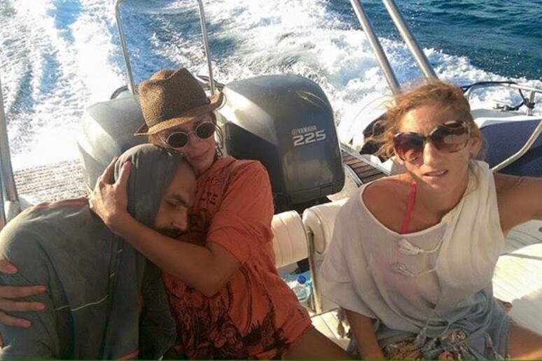 La foto mostra la turista greca Sandra Tsiligeridu mentre abbraccia il profugo siriano salvato in mare (dal profilo Facebook della donna) - RIPRODUZIONE RISERVATA