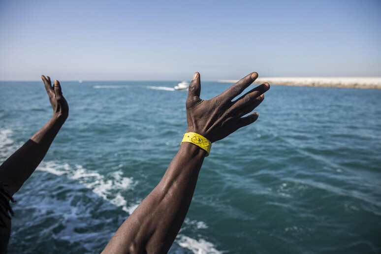 Le braccia di un migrante durante uno sbarco © ANSA/AP