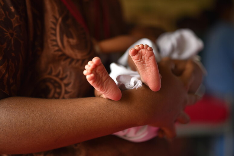 Una donna con in braccio un neonato © ANSA/EPA