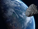 Rappresentazione artistica del passaggio di un asteroide vicino alla Terra, a distanza di sicurezza (fonte: Pixabay) (ANSA)