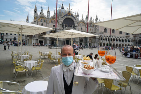 Un cameriere dello storico Caffè Lavena al lavoro, in piazza San Marco © ANSA